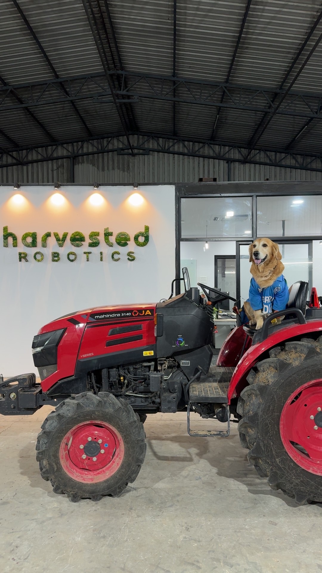 Denver in the driver's seat of the Mahindra tractor inside the Harvested Robotics workshop